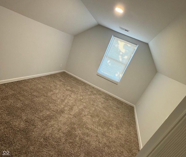 bonus room with carpet flooring and vaulted ceiling