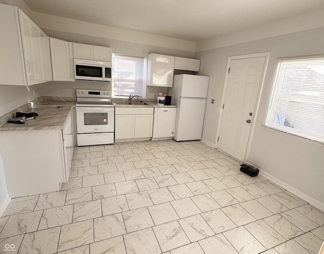 kitchen with sink, white cabinets, and white appliances