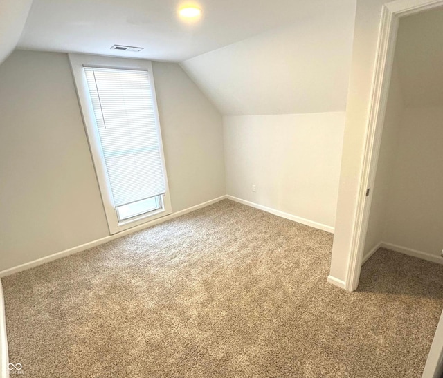 bonus room with carpet flooring, a healthy amount of sunlight, and lofted ceiling