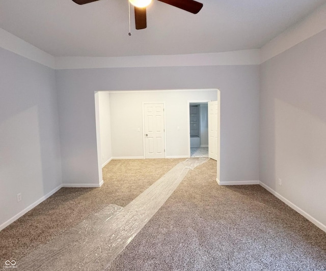 carpeted spare room featuring ceiling fan