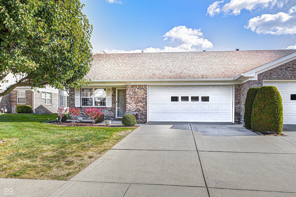 ranch-style home with a front yard and a garage