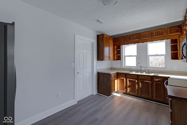 kitchen with sink, light hardwood / wood-style flooring, and a textured ceiling