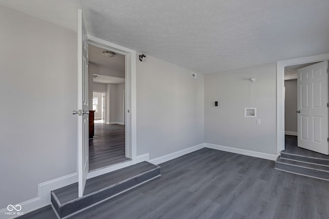 empty room featuring dark hardwood / wood-style flooring and a textured ceiling