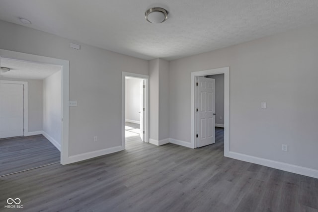 spare room with light hardwood / wood-style floors and a textured ceiling