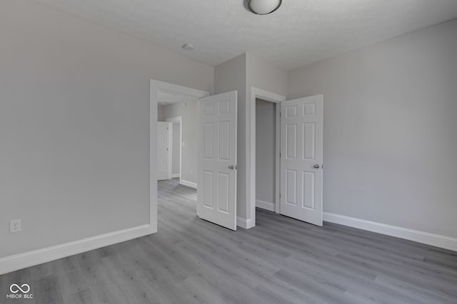 unfurnished bedroom with light hardwood / wood-style floors and a textured ceiling