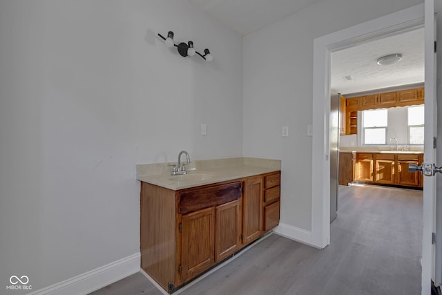 bar with sink and light hardwood / wood-style floors