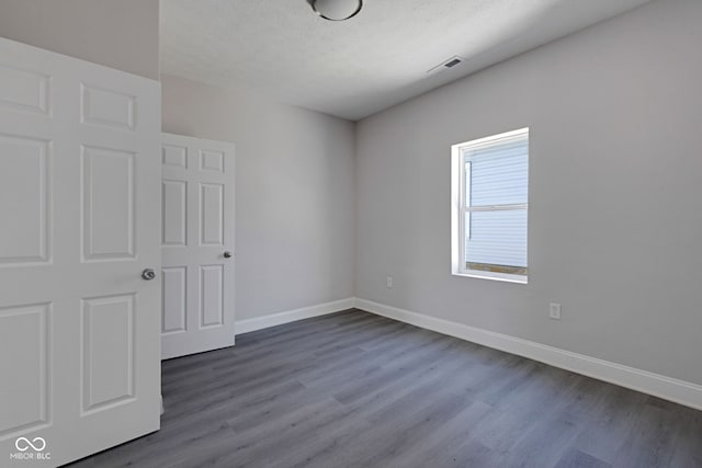 unfurnished bedroom with wood-type flooring and a textured ceiling