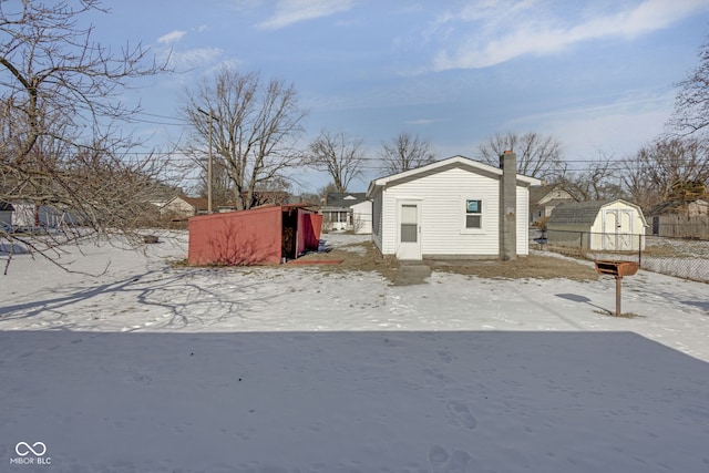 view of snow covered exterior with a shed