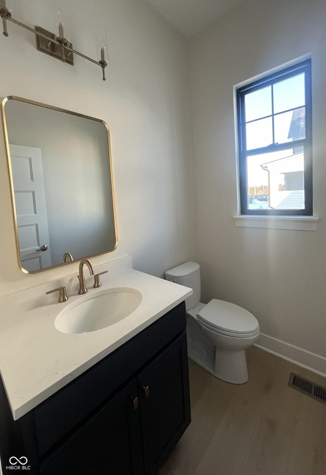 bathroom with vanity, hardwood / wood-style floors, and toilet