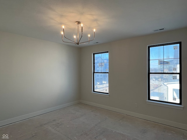 unfurnished room featuring plenty of natural light and a notable chandelier