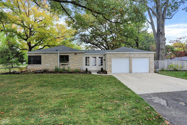 ranch-style house featuring a garage and a front lawn