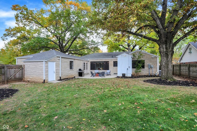 rear view of property with a yard and a patio