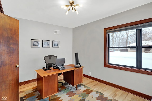 office area with an inviting chandelier and light hardwood / wood-style flooring