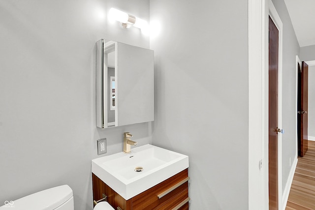 bathroom with vanity, hardwood / wood-style flooring, and toilet