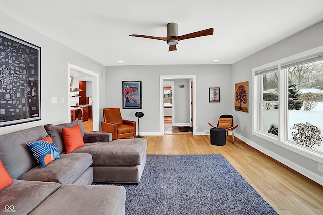 living room with wood-type flooring and ceiling fan