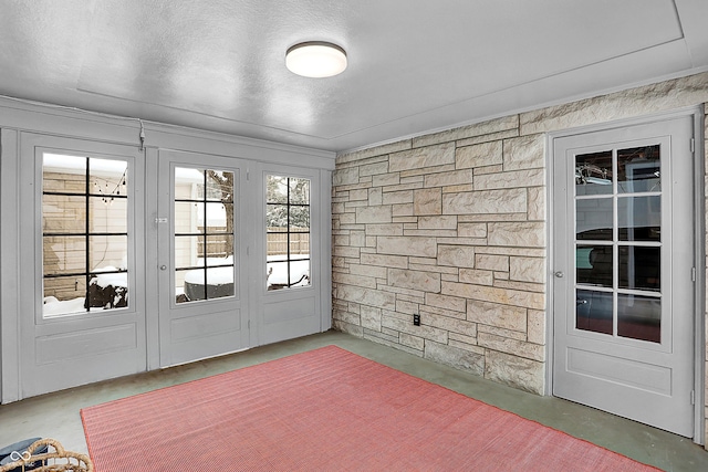 doorway to outside with concrete flooring and a textured ceiling