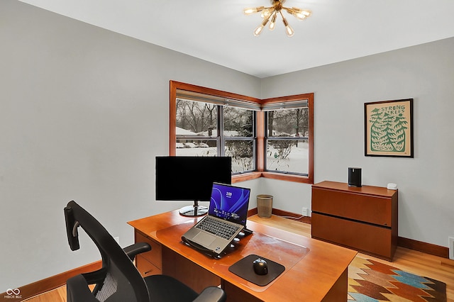 office area with an inviting chandelier and light hardwood / wood-style flooring