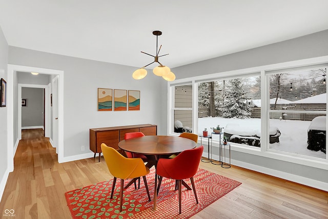 dining area with a notable chandelier and light hardwood / wood-style flooring