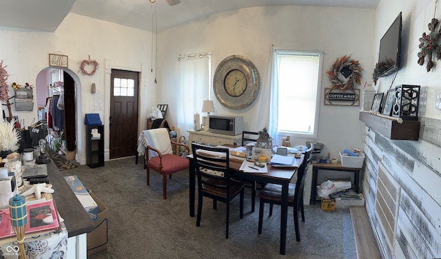 dining area featuring plenty of natural light and dark colored carpet