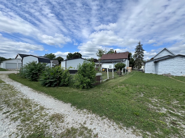 view of yard with a garage and an outbuilding