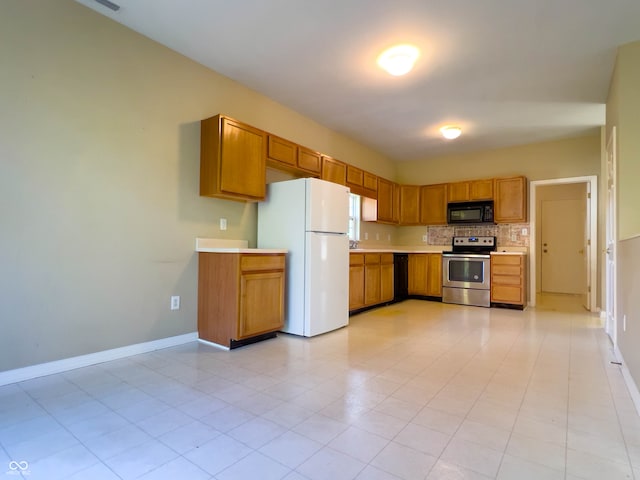 kitchen featuring white fridge, backsplash, light tile patterned flooring, and electric range