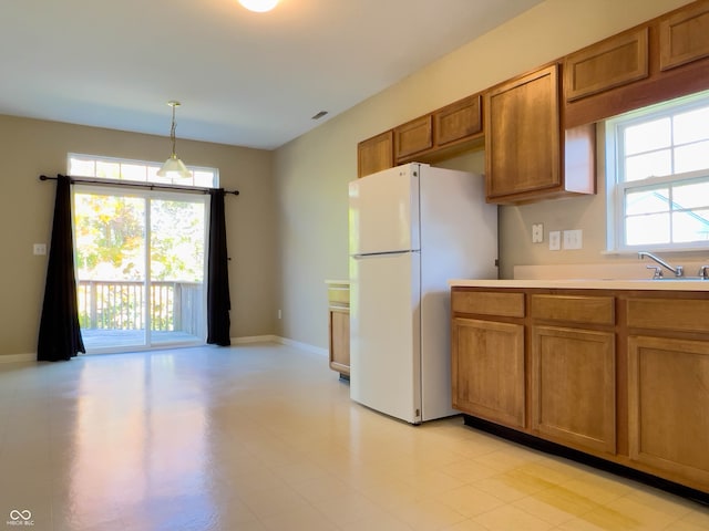 kitchen with pendant lighting, white fridge, and plenty of natural light