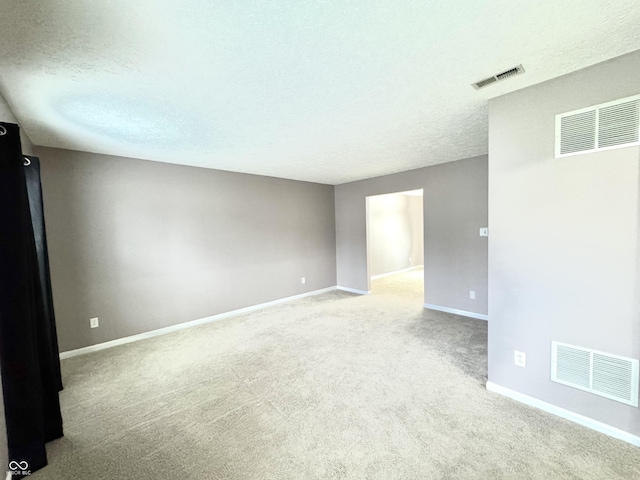 unfurnished room with carpet and a textured ceiling