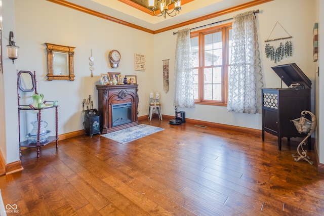 living area featuring an inviting chandelier, ornamental molding, and hardwood / wood-style flooring