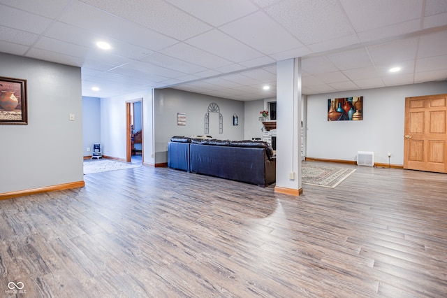 living room featuring a paneled ceiling and wood-type flooring