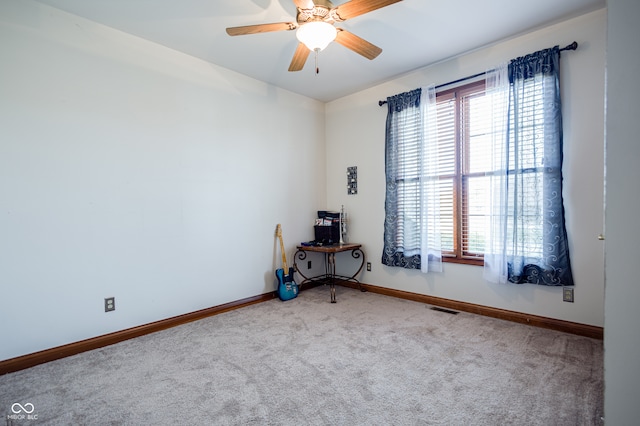 carpeted spare room with ceiling fan