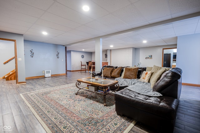 living room with a paneled ceiling and wood-type flooring