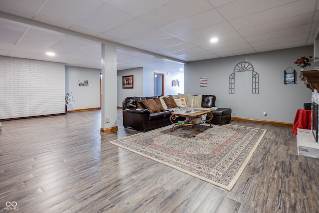 living room featuring wood-type flooring and a drop ceiling