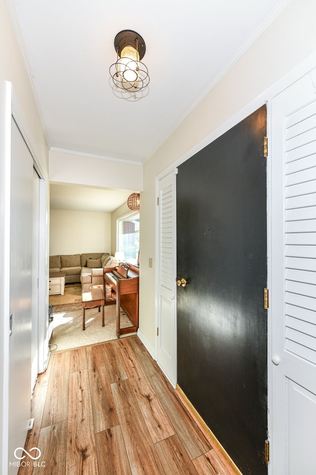 foyer with ornamental molding and light hardwood / wood-style flooring