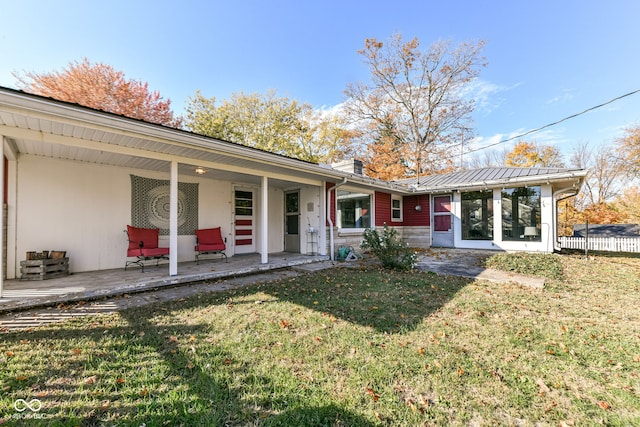 rear view of property with a lawn