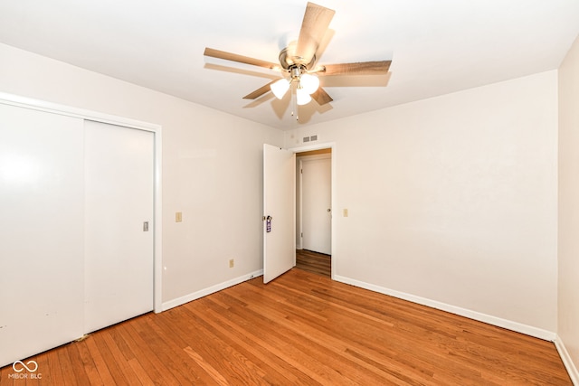 unfurnished bedroom with a closet, light hardwood / wood-style floors, and ceiling fan