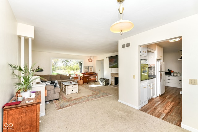 living room with light hardwood / wood-style flooring and a brick fireplace