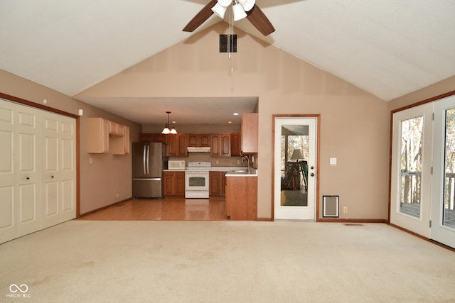 kitchen featuring pendant lighting, white appliances, sink, and light carpet