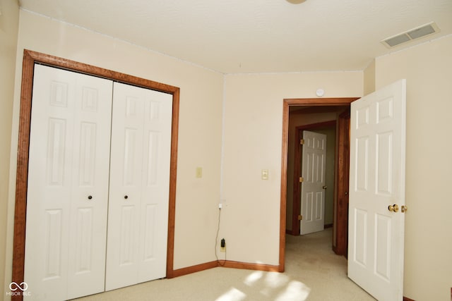 unfurnished bedroom featuring a closet and light carpet