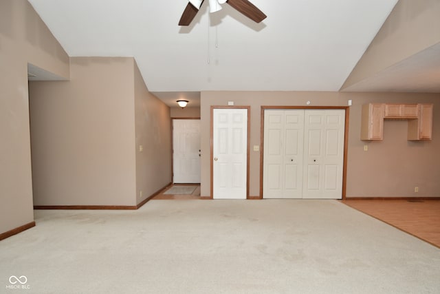 interior space with lofted ceiling, light colored carpet, and ceiling fan