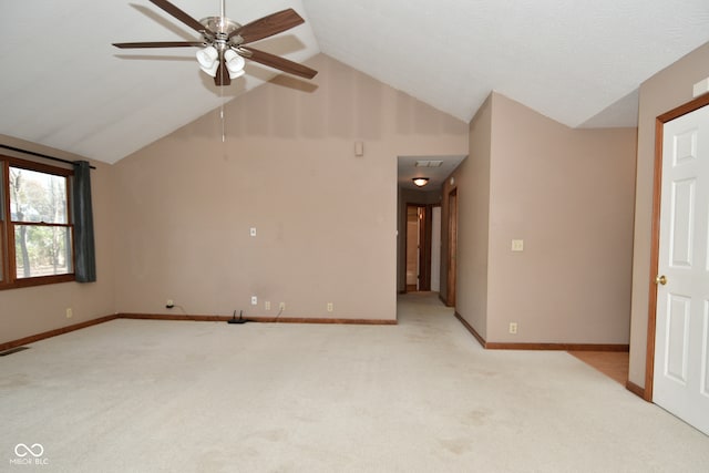 carpeted spare room with ceiling fan and vaulted ceiling