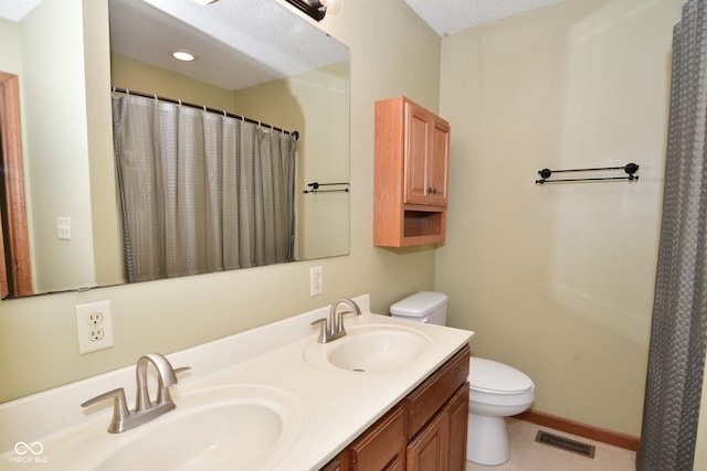 bathroom with tile patterned floors, toilet, a textured ceiling, vanity, and walk in shower