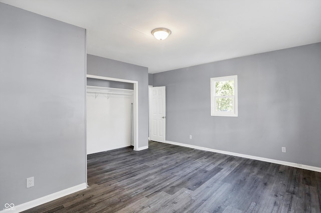 unfurnished bedroom featuring dark hardwood / wood-style floors and a closet