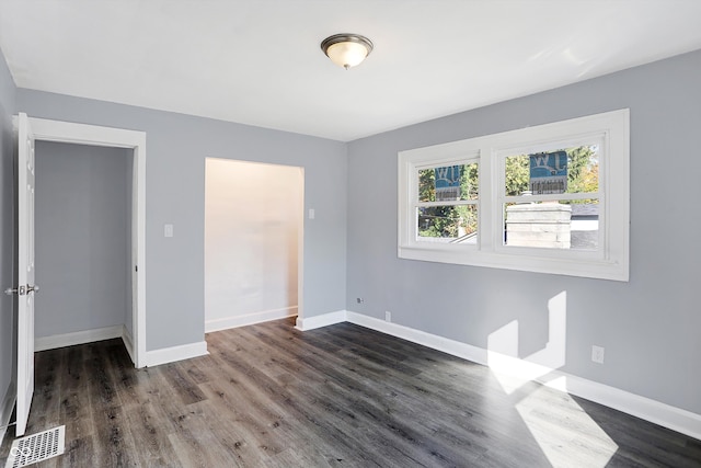 unfurnished room with dark wood-type flooring