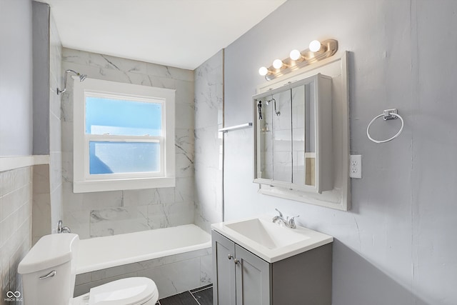 full bathroom featuring toilet, tiled shower / bath, and vanity