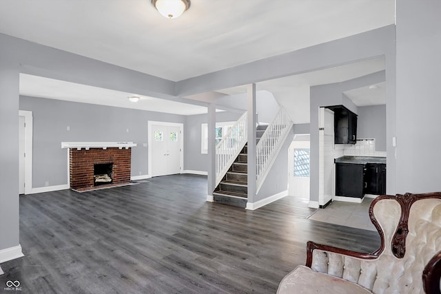 living room featuring a brick fireplace and dark hardwood / wood-style floors