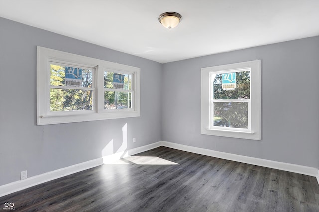 unfurnished room with a healthy amount of sunlight and dark hardwood / wood-style floors