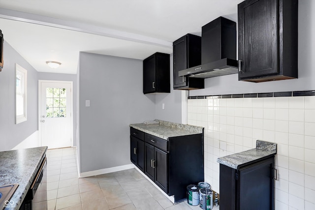 kitchen featuring wall chimney exhaust hood, light tile patterned flooring, stainless steel dishwasher, and tile walls