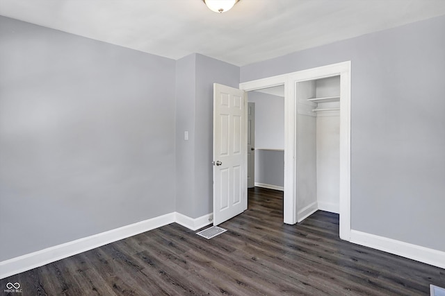 unfurnished bedroom with a closet and dark hardwood / wood-style flooring