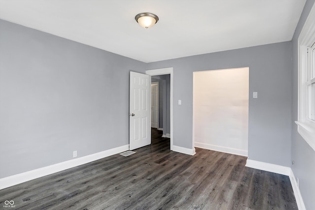 unfurnished room featuring dark wood-type flooring