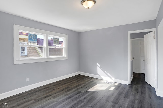 unfurnished room with dark hardwood / wood-style flooring